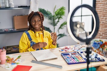 African american woman artist recording video showing pencils at art studio