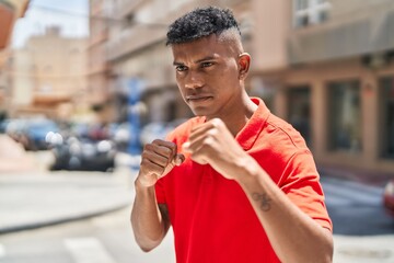 Young latin man boxing at street