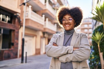 African american woman executive smiling confident standing with arms crossed gesture at street