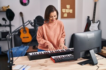 Middle age woman musician playing piano at music studio
