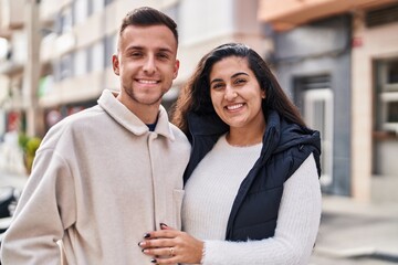 Man and woman couple hugging each other standing at street