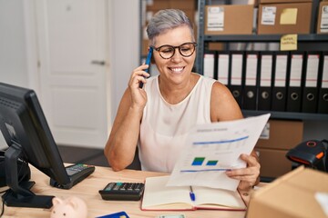 Middle age woman ecommerce business worker talking on the smartphone at office