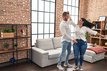 Man and woman couple smiling happy dancing at home