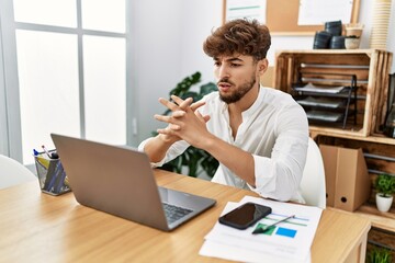 Young arab man using laptop working at office