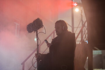 Sound engineer with a microphone on the set. A professional sound engineer at work on the filming...