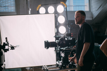 Director of photography with a camera in his hands on the set.  Filming process indoors, studio