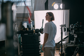 The director of photography is a woman behind a video camera on the set. A professional...