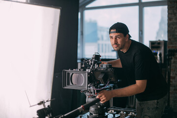 Director of photography with a camera in his hands on the set.  Filming process indoors, studio