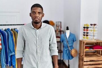 Young african american man working as manager at retail boutique depressed and worry for distress, crying angry and afraid. sad expression.