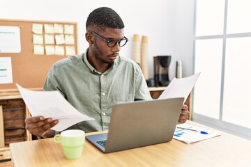Young african american man reading document working at office