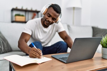 Young african american man using laptop studing at home