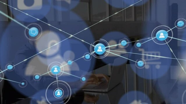 Animation of connections with icons over asian man working on laptop