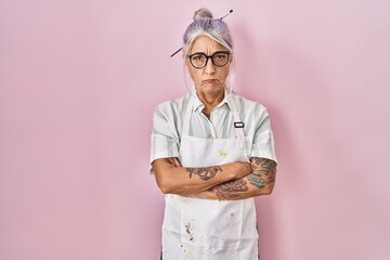 Middle age woman with grey hair wearing artist look skeptic and nervous, disapproving expression on...