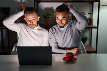 Homosexual couple using computer laptop confuse and wondering about question. uncertain with doubt,...