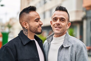 Two men couple smiling confident standing together at street