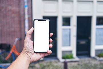 Man holding smartphone showing white blank screen at street