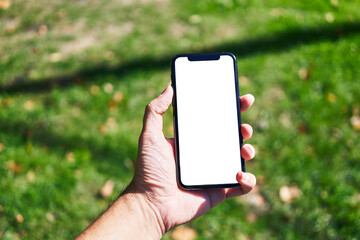 Man holding smartphone showing white blank screen at park