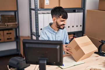 Young hispanic man ecommerce business worker scanning package at office