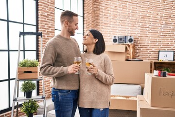 Man and woman couple smiling confident toasting with champagne at new home