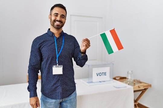 Young hispanic man smiling confident holding hungary flag standing at electoral college