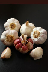 Garlic bulbs and cloves on the black surface. Brazilian spice.