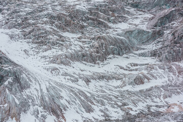 Awesome nature backdrop with glacier close-up. Beautiful abstract pattern of icefall. Natural background with mountain glacier. Amazing nature of mountains. Simple texture. White snow on glacial ice.