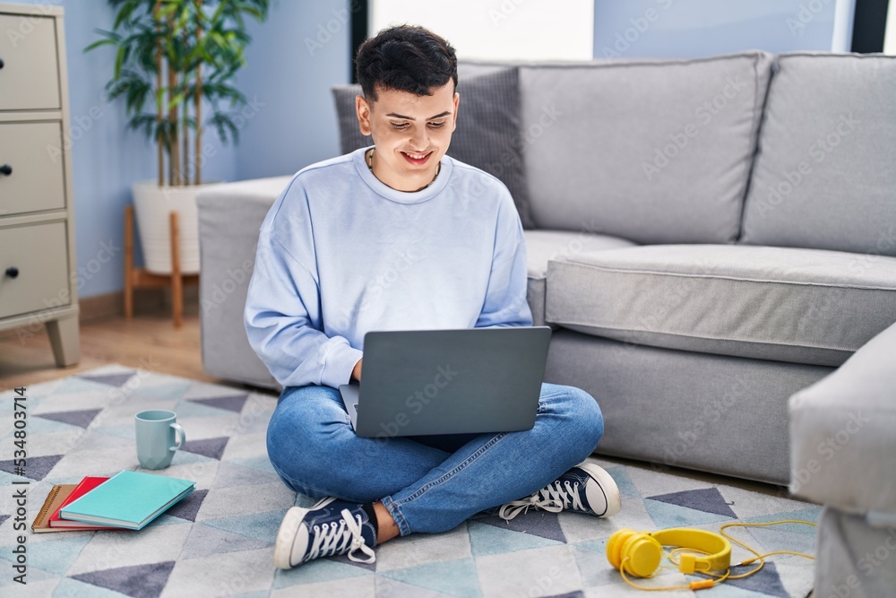 Poster non binary person studying using computer laptop sitting on the floor with a happy and cool smile on