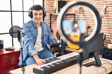 Non binary person doing online music tutorial looking positive and happy standing and smiling with...