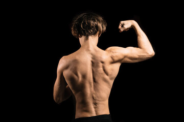 Fototapeta premium athletic muscular back of a man on a dark background.