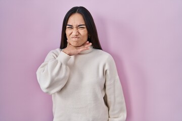 Fototapeta premium Young south asian woman standing over pink background cutting throat with hand as knife, threaten aggression with furious violence