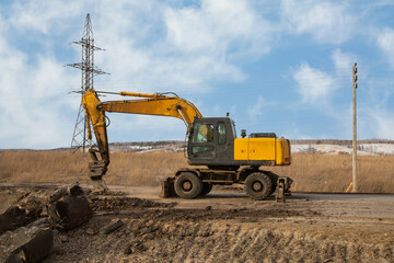 Obraz premium A working excavator with attachments on the construction of a road junction.