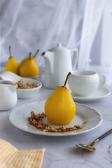 Delicious homemade autumn dessert: pears boiled in white wine. Pears in white wine with caramel on a light marble table. Light fruit dessert. 