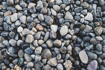 non-round pebbles on the beach photo, top view