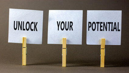 Unlock your potential symbol. Concept words Unlock your potential on white papers on wooden clothespins. Beautiful grey table grey background. Business unlock your potential concept. Copy space.