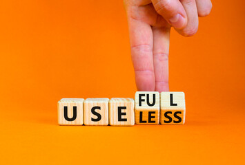 Useful or useless symbol. Concept words Useful or Useless on wooden cubes. Businessman hand. Beautiful orange table orange background. Business useful or useless concept. Copy space.