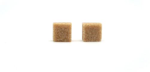 2 carrés de sucre roux en morceau isolés sur fond blanc