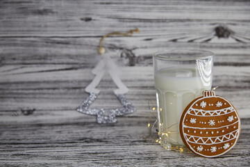 Milk with cookie for Santa. Handmade fresh cookies and glass with milk on the vintage wooden table. Christmas traditions. Aesthetic atmosphere and festive Christmas mood background. Copy space