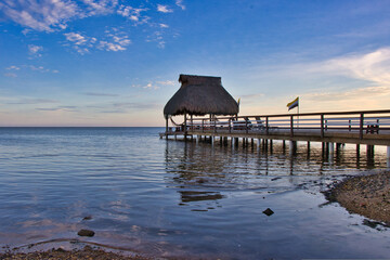 over water bungalow with jetty at sunset