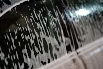 Naklejka na ściany i meble The car is foamed at the self-service car wash.