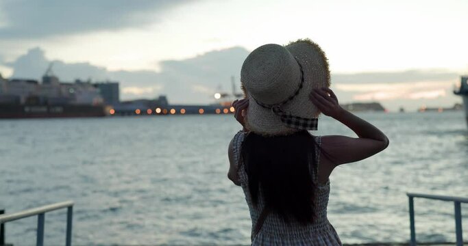 Woman look at the sunset city skyline at seascape