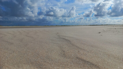 Sandstrand an der Küste vor heraufziehendem Sturm mit dunklen Wolken