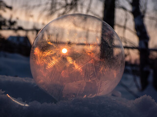 Macro shot of round, frozen soap bubble forming beautiful leaf and tree like pattern while freezing...