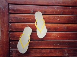 blue and yellow flip flops on wooden floor. Top view