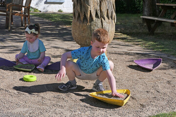Children having fun playing with toys and stones in garden