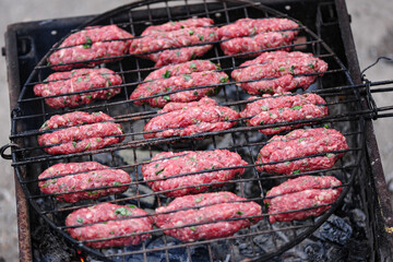 The process of cooking . Raw lula kebabs are fried on the grill . Summer picnic grill