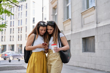 Beautiful young women at a street looking at a phone
