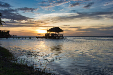 sunset in the caribbean with over water bungalow