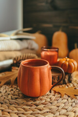 Hot steaming Cup of tea with autumn leaves, pumpkins and spices on the windowsill. Autumn mood.