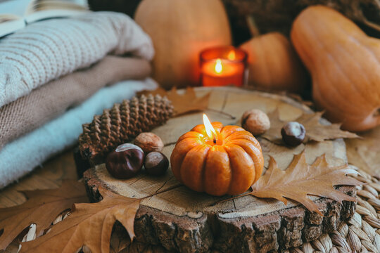 Burning candle in the shape of a pumpkin, autumn aesthetic mood