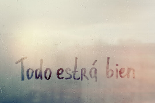 Lettering Spanish text Todo estra bien everything will be fine in english on sunset wet window